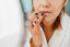Applying lip balm to dry lips as part of a winter lip care routine